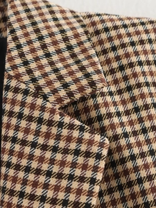 Macro della trama del tessuto di lana pied-de-poule marrone di un blazer da donna