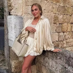 Elegante champagnerfarbene Satinjacke mit Puffärmeln und weißem Spitzenrock mit Stickerei