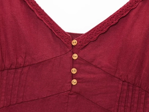 Détail du col en V avec dentelle au crochet et boutons en bois sur robe lin bordeaux