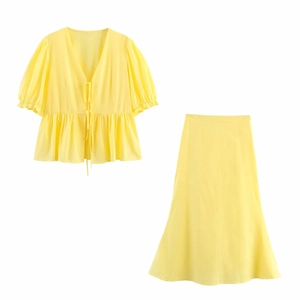 Détail d'un ensemble d'été jaune avec haut à col en V et jupe midi de coupe en A