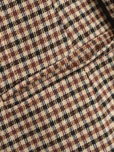 Dettaglio macro della trama pied-de-poule per blazer e giacche autunnali da donna