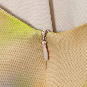 Detaillierte Nahaufnahme des verdeckten Reißverschlusses und Netzdrucks am Midikleid