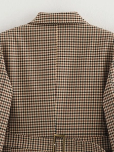 Dettaglio del retro del blazer pied-de-poule con cucitura sartoriale e fibbia metallica