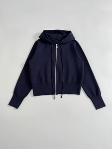 Detail of navy blue knitted hoodie showing smooth zipper and ribbed cuffs for casual wear