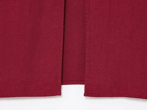 Détail de la fente latérale sur robe midi rouge foncé en lin avec coutures soignées