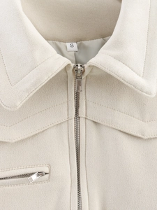 Detailed close-up of beige faux suede jacket collar with stitching and zipper detail
