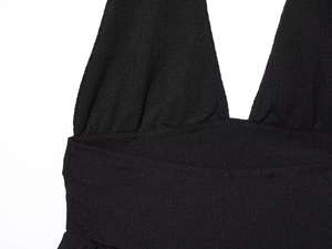 Dettaglio del top nero a lupetto con trama in maglia a coste premium e scollatura a V profonda