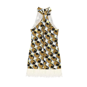 Detail of geometric print halter dress featuring vibrant patterns and white feather hem trim