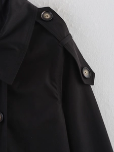 Detailed macro of trench coat shoulder straps with elegant tortoiseshell texture buttons