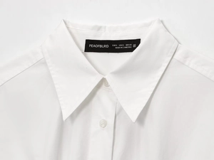 Detailed close-up of white cotton shirt collar with brand label and size tag information