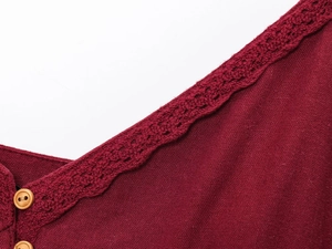 Détail d'une robe en lin rouge foncé avec col en V, bordure en dentelle et boutons bois