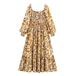Detailed close-up of smocked bodice and botanical leaf print on a long sleeve dress