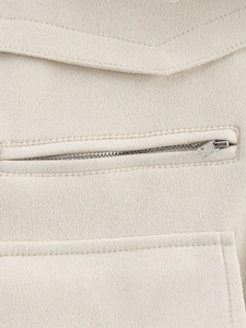 Detail of beige faux suede fabric with metallic silver zipper pocket and stitching