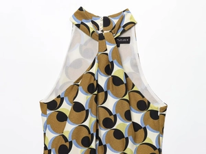 Flat lay detail of halter neck top with geometric circular prints and neck button