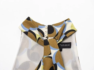 Detail of high collar back with three buttons and hanging strap on geometric print top