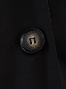 Detailed macro view of black twill fabric and premium marble-patterned four-hole button