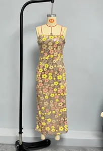 Détail des paillettes or champagne et broderies florales sur une robe longue à bretelles
