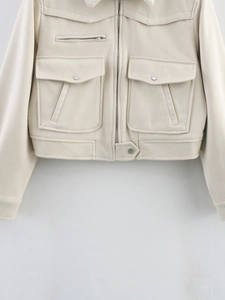 Detail of cream faux suede jacket featuring utility pockets and metallic hardware accents