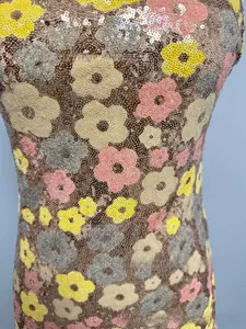 Gros plan de broderies à sequins floraux scintillants sur le tissu d'une robe de soirée