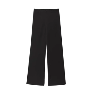 Detail van een zwarte broek met hoge taille, wijde pijpen en een elegante satijnen glans