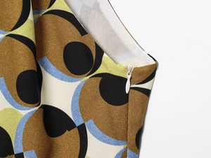 Close-up of geometric pattern dress showing the side invisible zipper and fine stitching