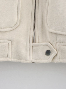Detail of silver zipper and metal buckle on faux suede jacket with clean stitching
