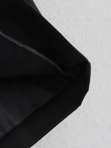 Detailed macro view of black synthetic fabric showing dense weave and matte finish texture