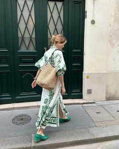 Schickes weißes Midikleid mit grüner Blumenstickerei und Puffärmeln in einer urbanen Kulisse