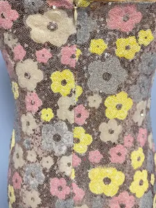 Détail de broderie de paillettes florales avec fermeture éclair invisible au dos