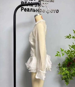 Detailansicht von weißem Chiffon-Oberteil und gestuftem Rüschen-Minirock-Set