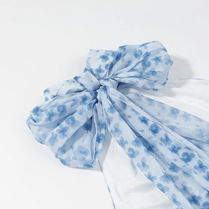 Detail of blue floral print dress featuring a large bow and watercolor silk fabric
