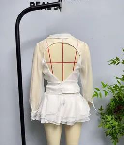 Detail eines weißen zweiteiligen Chiffon-Sets mit rückenfreiem Oberteil und Stufenrock