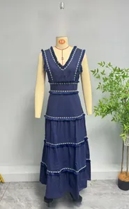 Détails de la robe à col en V avec broderie blanche et bordures à franges sur bleu marine