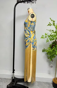 Detailansicht des ärmellosen Ethno-Kleides mit langen goldenen Fransen am Saum