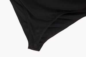 Detail eines schwarzen Bodys mit verstärkten Druckknöpfen und hochwertigen Nähten