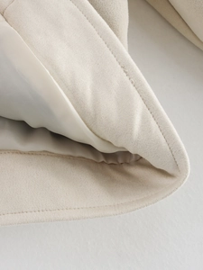 Detail of premium beige faux suede jacket showing precise stitching and smooth satin lining