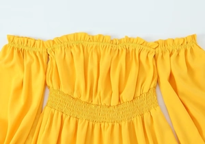 Détail de la robe jaune épaules dénudées avec encolure à volants et tissu fumé élastique