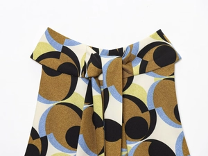 Close-up of geometric pop-style print on fabric featuring a brown and blue bow-tie detail