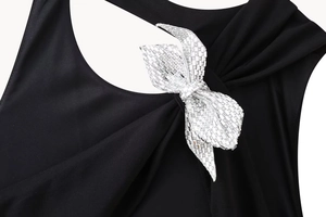 Nahaufnahme der silbernen Strass-Schleife an einem schwarzen Neckholder-Bodysuit