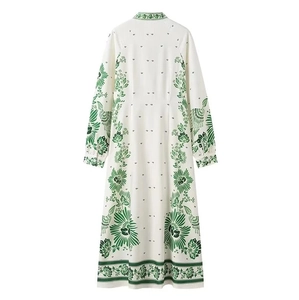 Detaillierte Nahaufnahme von Blumen- und Vogelmustern auf einem weißen Vintage-Kleid