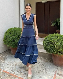 Détail d'une robe maxi à volants bleu foncé avec col en V et broderie blanche