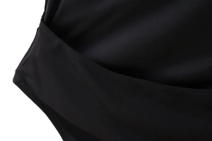 Detailaufnahme des schwarzen Neckholder-Bodys mit Wickeldesign und elastischem Rippstoff