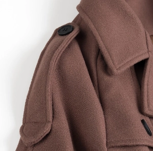 Close-up of brown wool blazer coat featuring detailed shoulder epaulettes and lapel