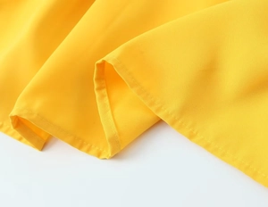 Détail de couture haute qualité sur le tissu en mousseline jaune d'une robe rétro française