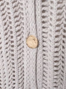Detail of light gray knit sweater with openwork texture and hammered gold button