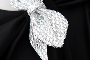 Detailansicht der luxuriösen Strass-Schleifen-Dekoration auf dem schwarzen Bodysuit