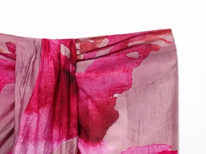 Dettaglio della gonna con stampa floreale rosa con pieghe morbide e motivo astratto