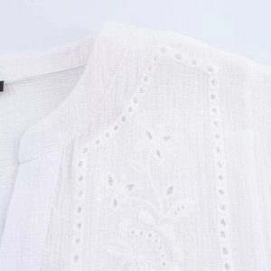 White embroidered hollow-out blouse featuring long sleeves and boho floral eyelet lace details