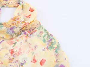 Detailed view of the chiffon floral dress neckline with small transparent buttons