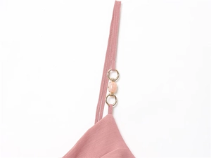 Detail of pink midi dress thin strap with gold metal rings and translucent bead accents